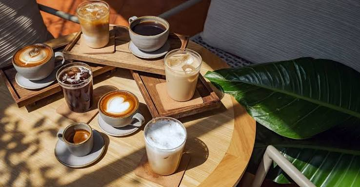 Corner Cafe beverages featuring assorted coffee drinks, iced coffee, latte, espresso, and creamy refreshments served on wooden trays outdoors.