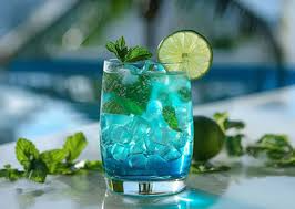 Refreshing blue mocktail with ice, fresh mint leaves, and a lime slice served in a clear glass.