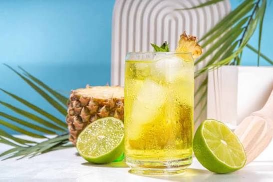 Refreshing pineapple and lime mocktail with ice, fresh lime slices, and pineapple garnish served in a clear glass.